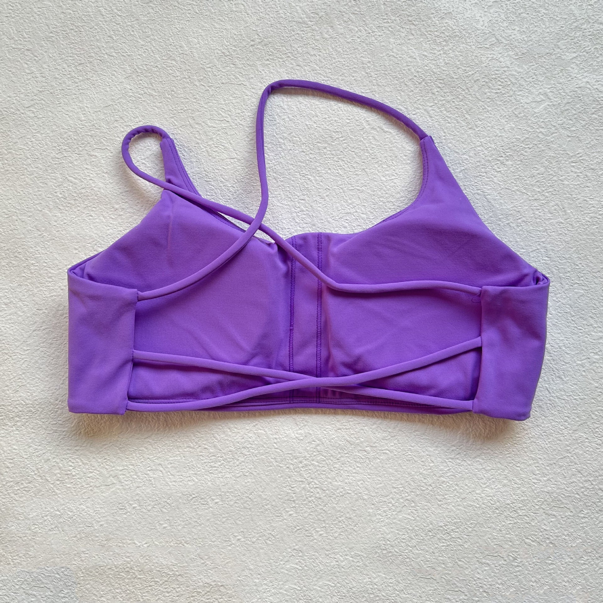 A nude fitness bra with thin straps and a cut-out back(Sports Bra)